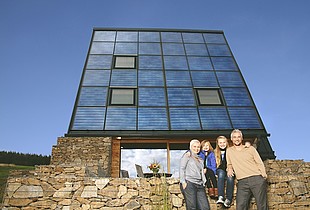Haus mit Solarthermie-Fassade und Familie